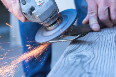 Personne qui affûte une lame de tondeuse